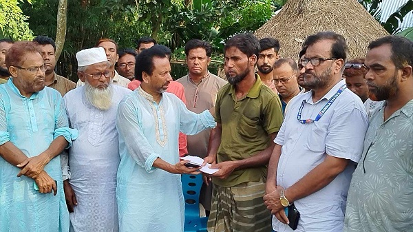 District BNP General Secretary Saidur Rahman Bachchu stands next to the family of the journalist killed in Raiganj